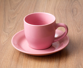 Pink color of empty coffee cup or tea cup on the wooden table