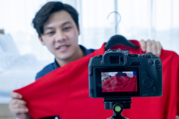 Asian young man blogger present and review product video broadcast live stream video to a social network. blogging, video blog, vlogging, online shopping, and social media concept