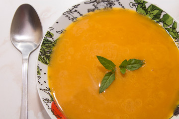 bowl with pumpkin soup on background