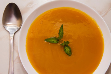 bowl with pumpkin soup on background