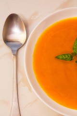 bowl with pumpkin soup on background
