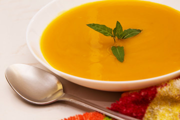 bowl with pumpkin soup on background