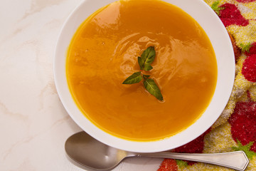 bowl with pumpkin soup on background