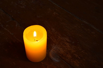 Obraz na płótnie Canvas yellow candle in the dark
