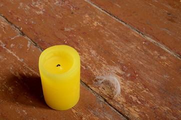 yellow candle on wooden background