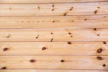 Obraz premium Background of planed boards of coniferous species under the imitation of a bar, with a beautiful pattern of the structure of trees with knots. Design backgrounds texture construction.