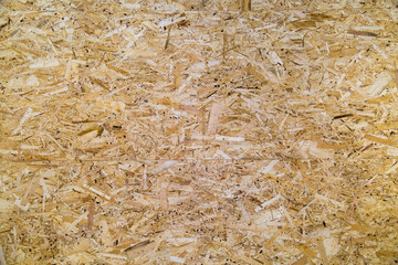 Background of OSB plate with a spike-groove pattern of planed wood in yellow.  Design backgrounds texture construction.