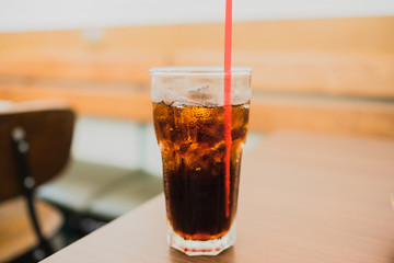 Close-Up Of Glass Of Cola With Ice On Wooden Table