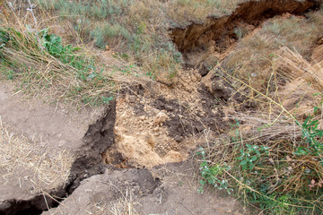 landslide in an environmentally hazardous area large crack in ground close up.