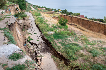 Fototapeta na wymiar cracks in the asphalt road due to landslides after a man made disaster.