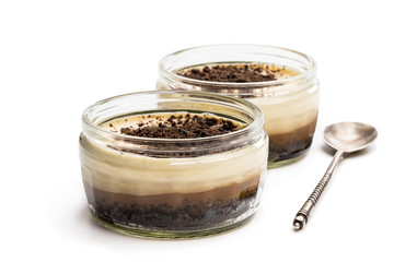 Layered creamy cappuccino cheesecakes in glass jar isolated on white