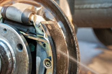 Car drum brake cleaning with spray.