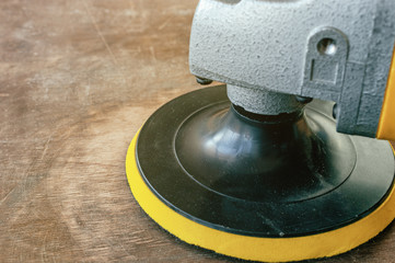 Sander machine on wooden background.