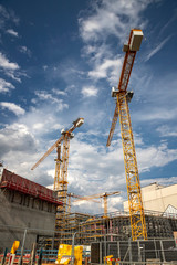 Day view of the construction site with cranes and building. Vertical view