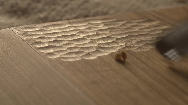 woodcarver carves a chisel notch in the board