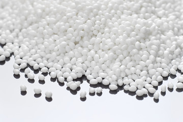 Closeup of a white plastic polymer in granules scattered