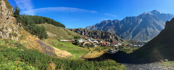 Fototapeta na wymiar Mountain village at sunny day in Kazbegi, Georgia