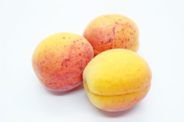 Tasty ripe beautiful apricots located on a white background