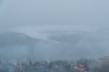  fog is falling on the city. houses in the mountains.