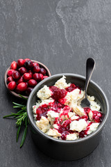 Potted aged Blue stilton cheese with cranberry sauce on black stone background