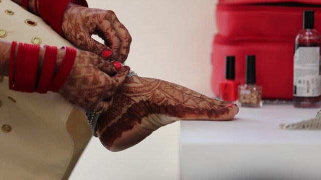 Indian bridal putting anklets in leg 
