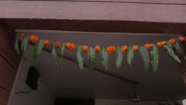 Marigold flower and green leaf decoration on door for welcome 