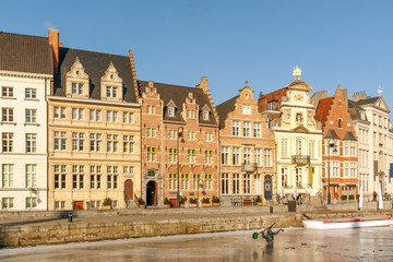 Row of typical Gothic houses on Korenlei quay along ice covered Leie river in winter, Ghent, Belgium
