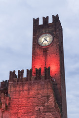 Beautiful castle clock tower at the evening with the red backlighting, castle with the red...