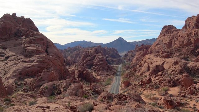 4K. Incredibly beautiful landscape in southern Nevada, United States. View of the Valley of Fire road from the heights. Vehicles pass the road to visit the park. Beautiful place. Natural concept. 