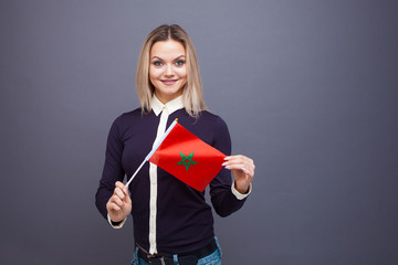 Immigration and the study of foreign languages, concept. A young smiling woman with a Morocco flag...