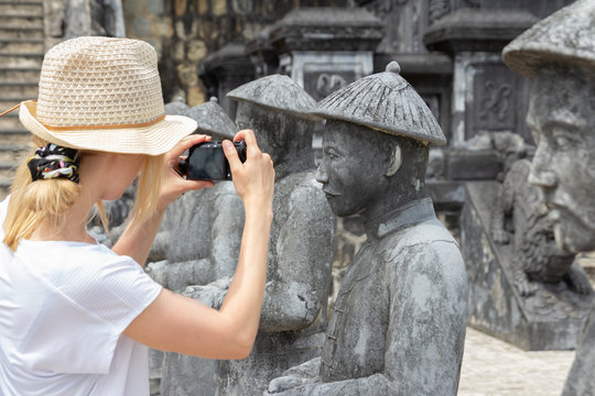 woman tourist taking picture of statues in Khai Dinh tomb in Hue