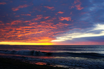 Fototapeta na wymiar Waves rolling in under a sunset sky
