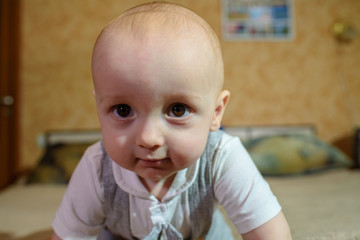 A small child plays on the bed at the parents. Happy childhood.