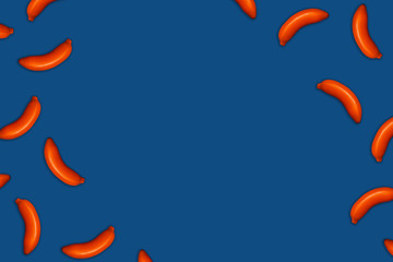 Classic blue food background of painted orange bananas. Flat lay, top view, place for text.