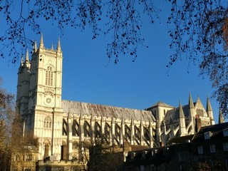 Famous Westminster Abbey near Parliament square in the centre of London England UK, the beautiful religious ancient historic building for royalty and famous English people side view blue sky sunshine 