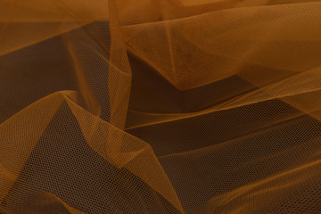 Beautiful close up of orange tulle fabric with textile texture background