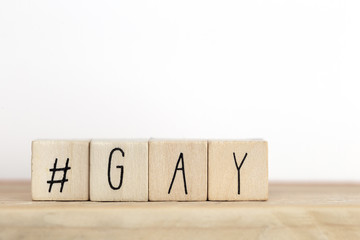 Wooden cubes with a hashtag and the word Gay, social media concept