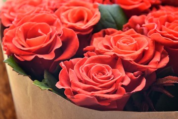 Red roses background. beautiful lush lava roses with selective focus in craft paper. St valentines bouquet made of amazing red roses. Bouquet of red roses. Present for Mother’s Day. St Valentine’s Day