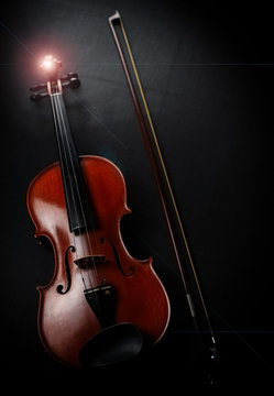 The wooden violin and bow put on black canvas background,Lens flare effect