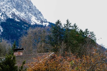 Fototapeta na wymiar Haus mit Schornstein vor Berg