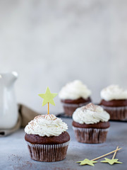 Delicious chocolate cupcakes with cream, decorated with a star. gray background, selective focus