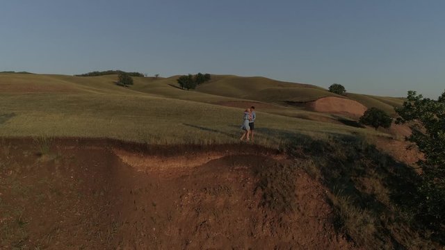 Guy and girl having fun at sunset. Aerial