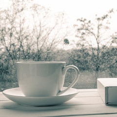Coffee cup over mirror background in rainy day,copy space