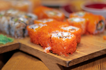 Blurred background with Japanese rolls on wooden board