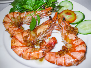Close-up of king prawns with greens and vegetables on a plate