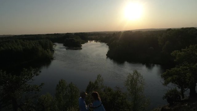 Guy and girl having fun at sunset. Aerial