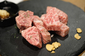Premium grade of sliced Japanese beef on black stone plate