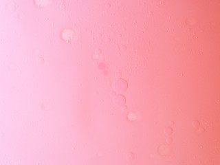 Oil and water in pink abstract background