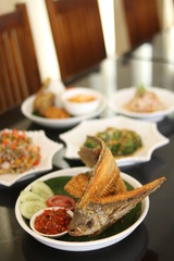 Spicy vegetables served on a leather table. Consists of leeks, sprouts, garlic, onions and fried fat.