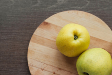  Ripe green apples on a round wooden cutting board on the table copy space. Harvest apples.